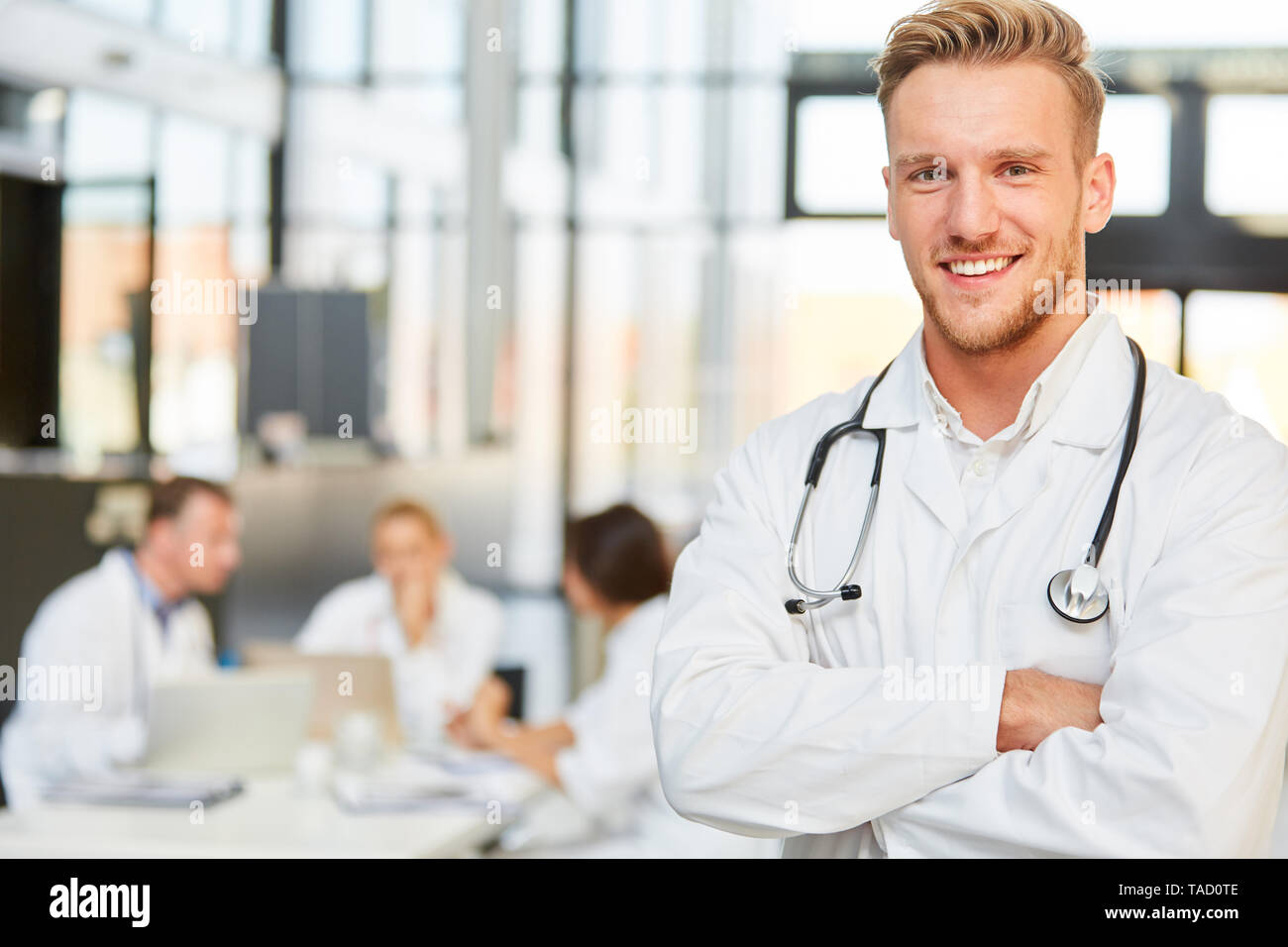 Lächelnden jungen Spezialisten oder medizinischen Assistenten in einer Sitzung im Krankenhaus Stockfoto