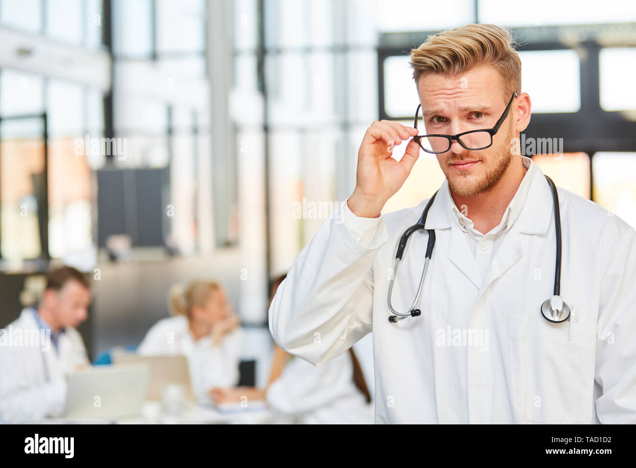 Arroganter Mann mit Brille als medizinische Assistentin in Ausbildung im Krankenhaus treffen Stockfoto