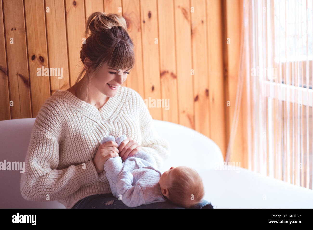 Lächelnde Mutter Holding schlafendes Baby im Zimmer. Die Mutterschaft. Mutterschaft. 20. Stockfoto