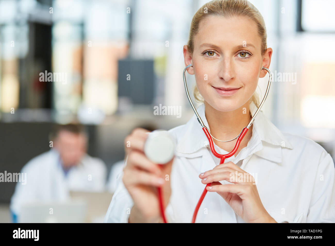 Junge Frau Doktor mit Stethoskop als Internist im Krankenhaus oder in der Arztpraxis Stockfoto