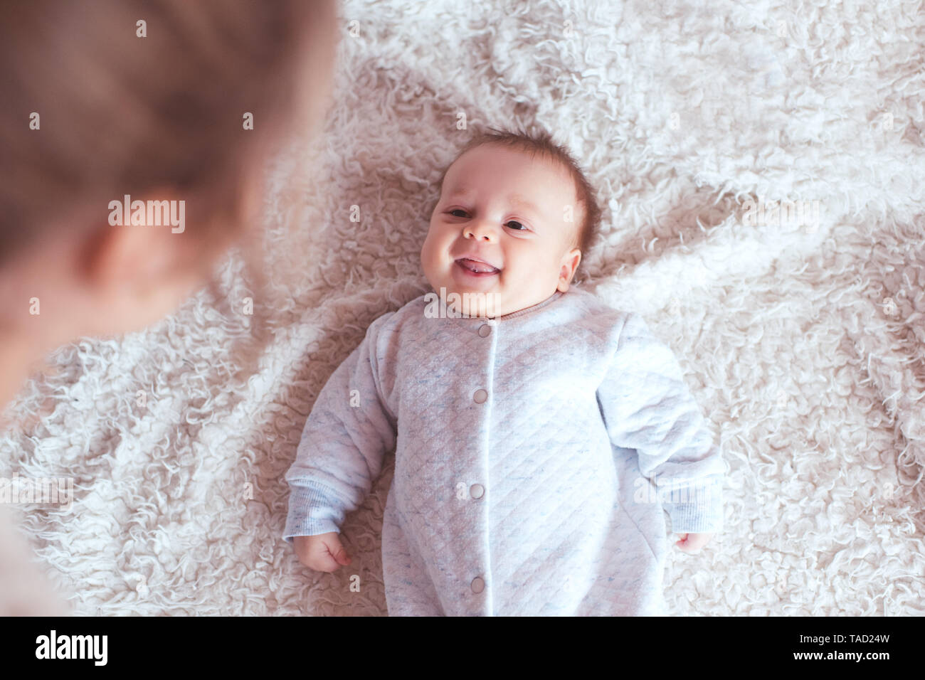 Cute Baby Boy bei Mutter und lächelnd im Bett zu liegen. Schauen einander an. Bis in den Morgen. Die Mutterschaft. Stockfoto