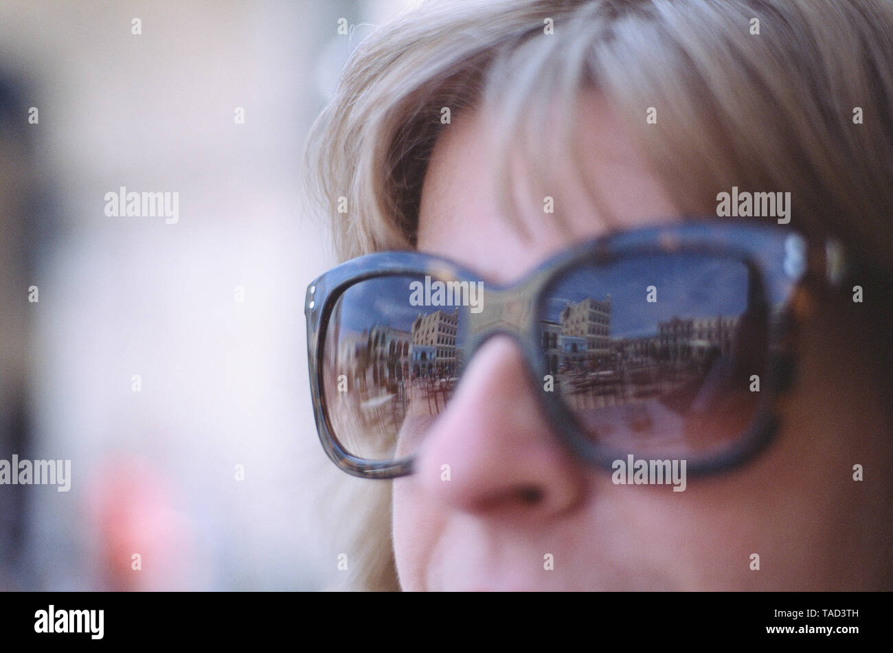 Eine Frau in der Sonne Brille blickt auf die Plaza Vieja, Havanna, Kuba Stockfoto