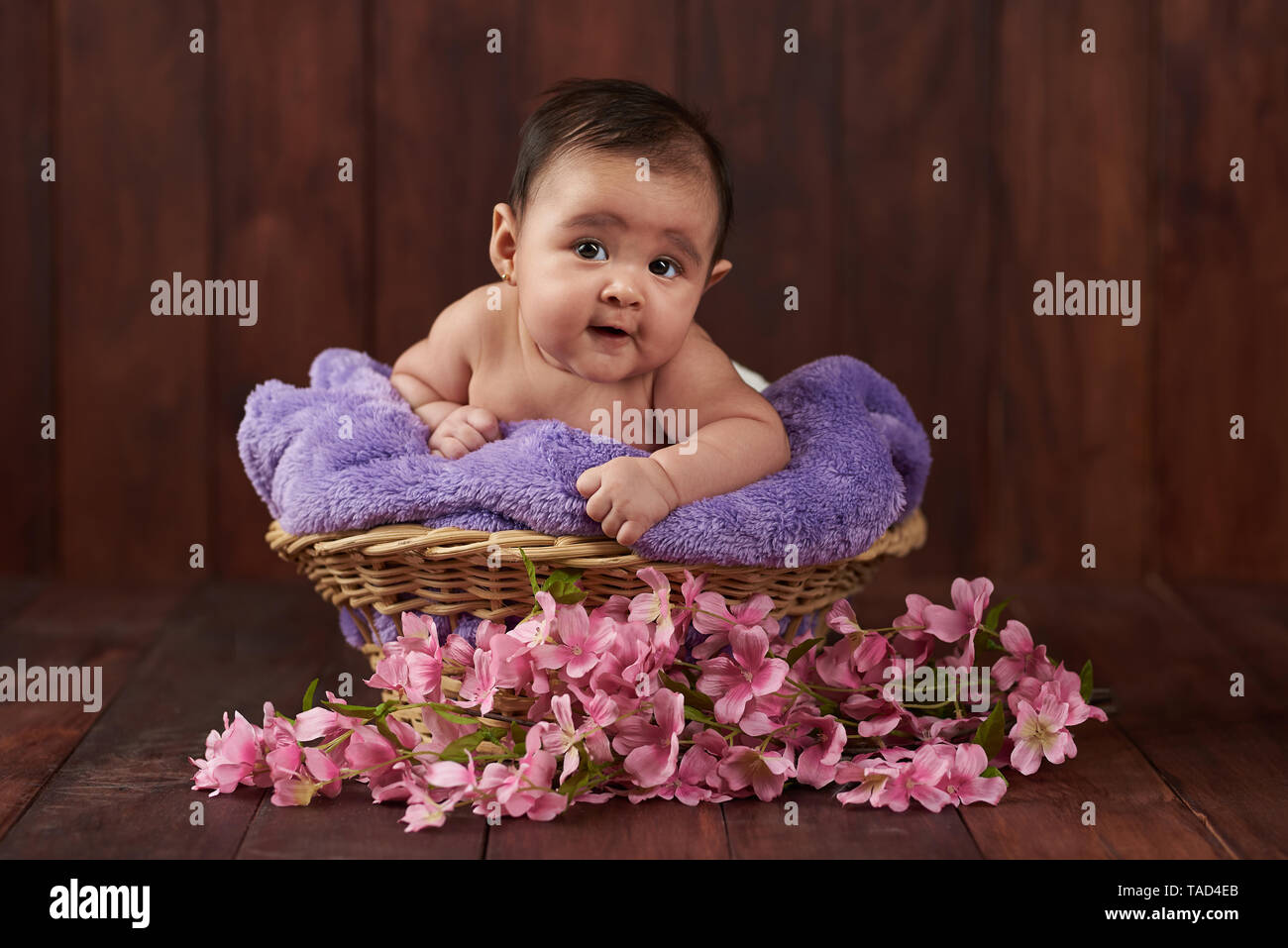 Lächelnd niedlichen Baby girl portrait auf dunklen Studio Hintergrund Stockfoto