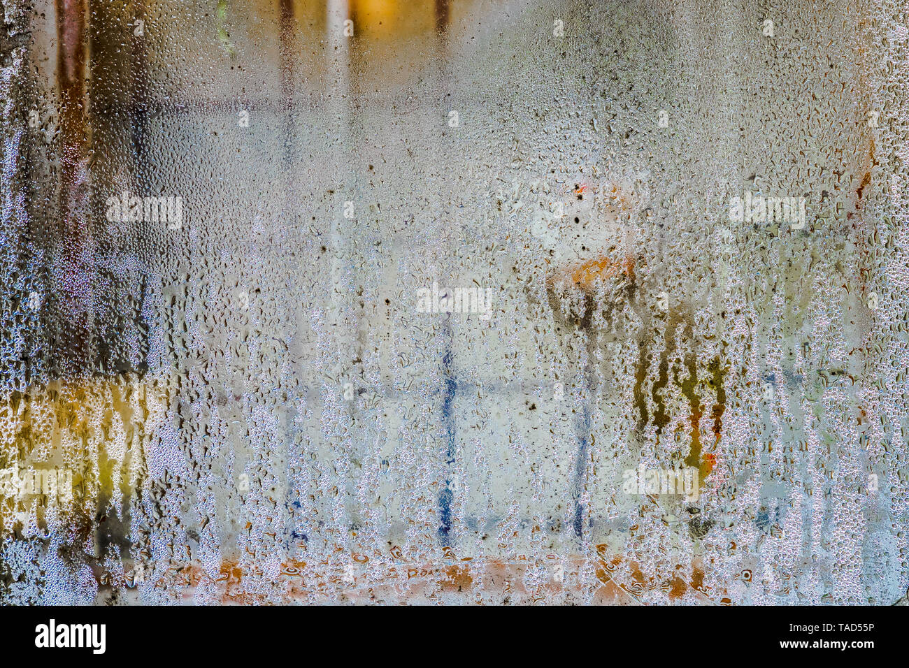 Wassertropfen auf Fensterglas. Ein eisernes Gitter zum Schutz ist sichtbar hinter dem Glas. Abstraktes Bild. Stockfoto