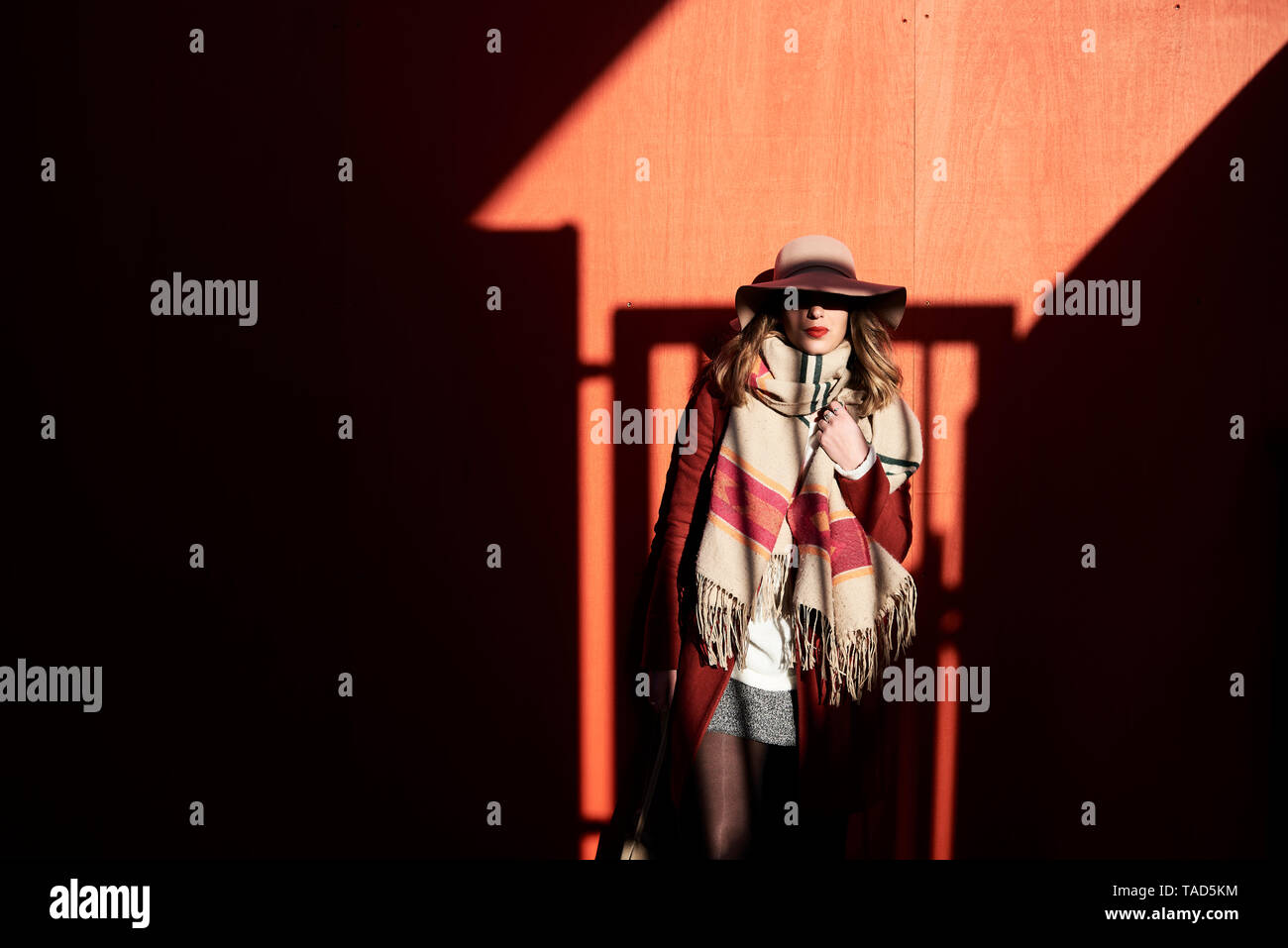 Stilvolle Frau trägt einen Schlapphut in Licht und Schatten Stockfoto