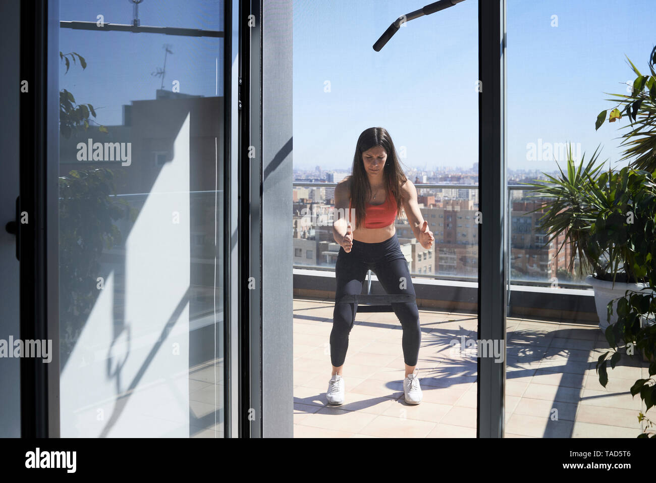 Sportliche junge Frau, die auf der Dachterrasse Stockfoto