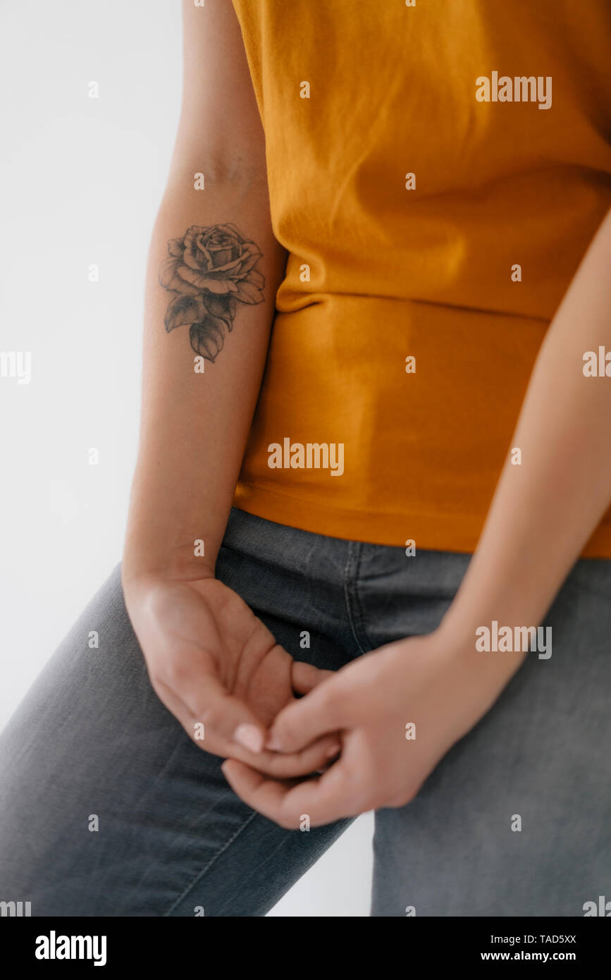 Nahaufnahme einer jungen Frau mit Rose Tattoo auf dem Arm Stockfoto