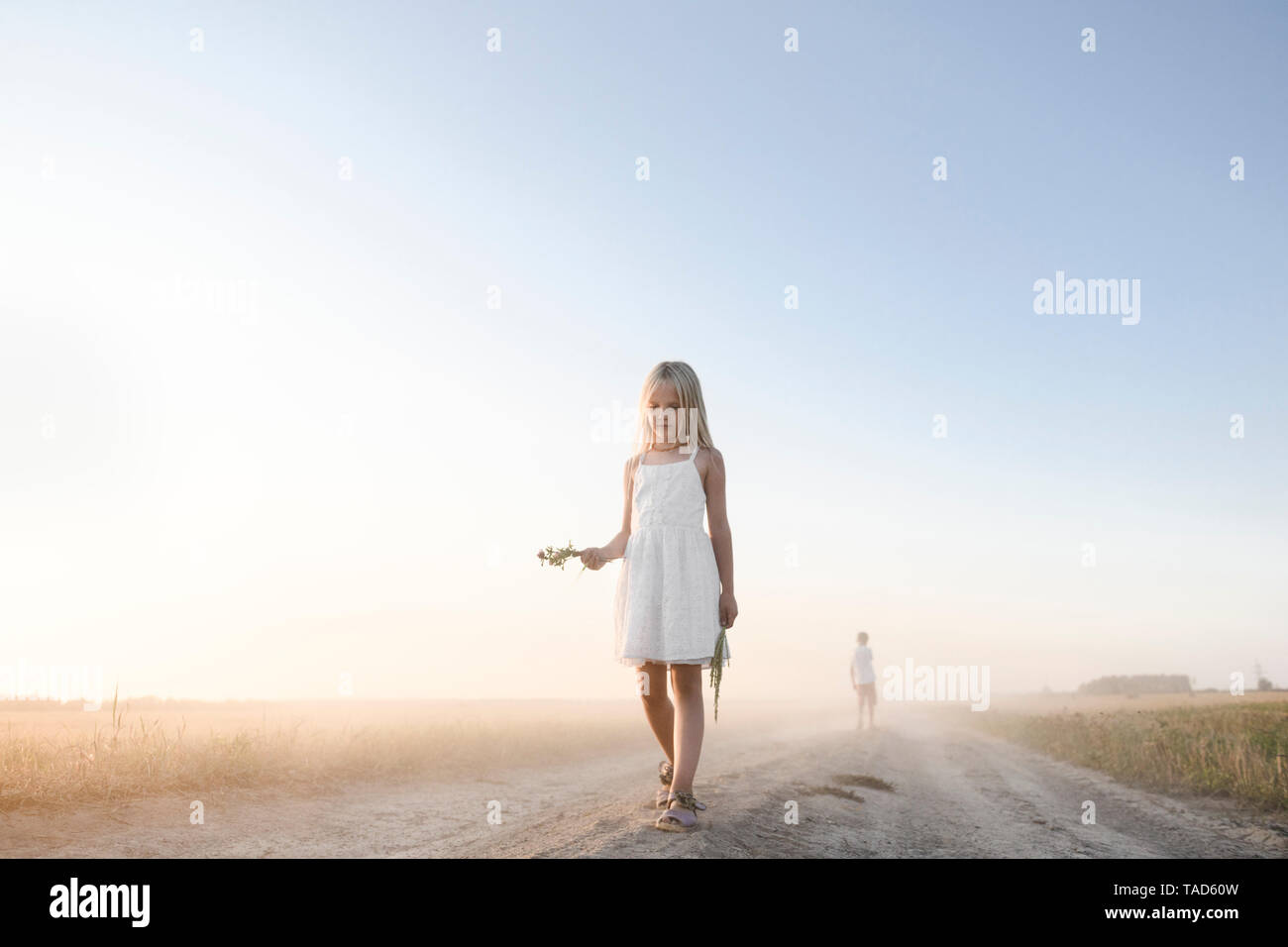 Mädchen gehen auf eine ländliche Feldweg Stockfoto