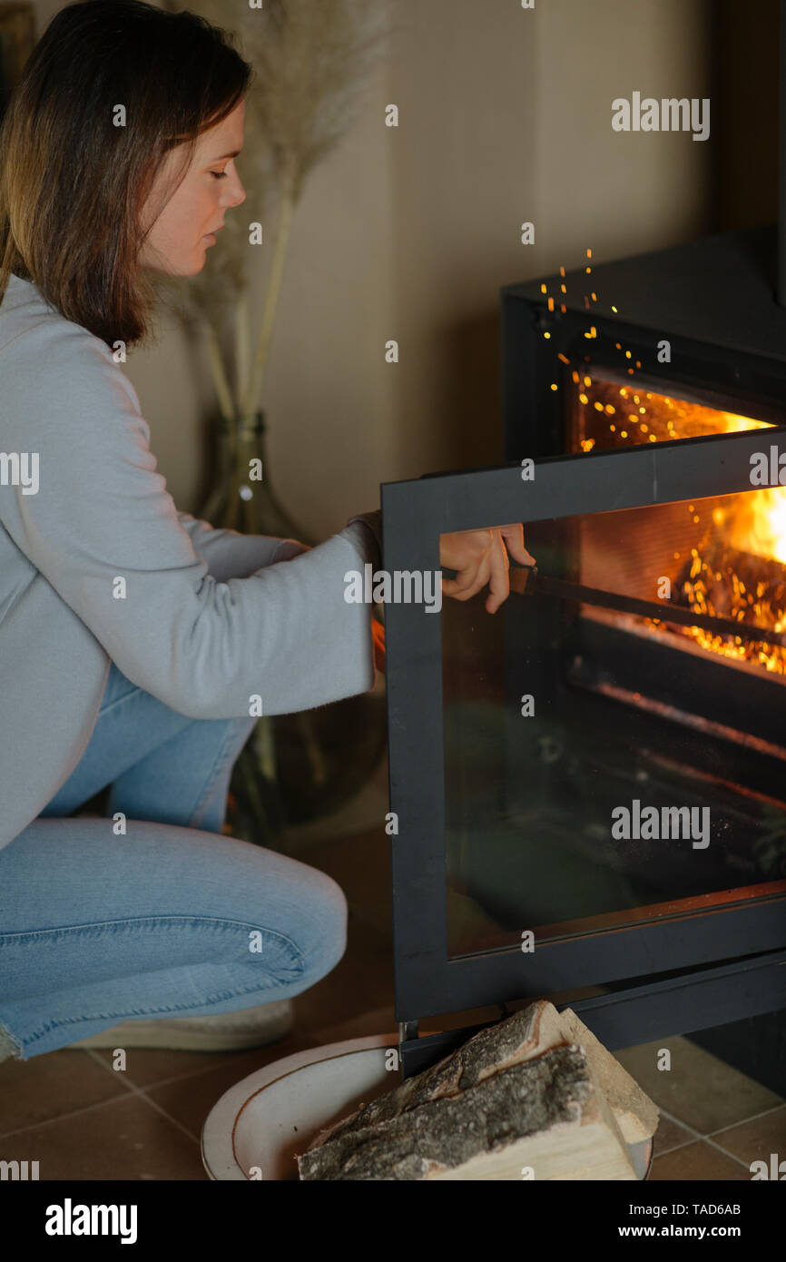 Frau, die Holz im Kamin verbrannt hat Stockfoto