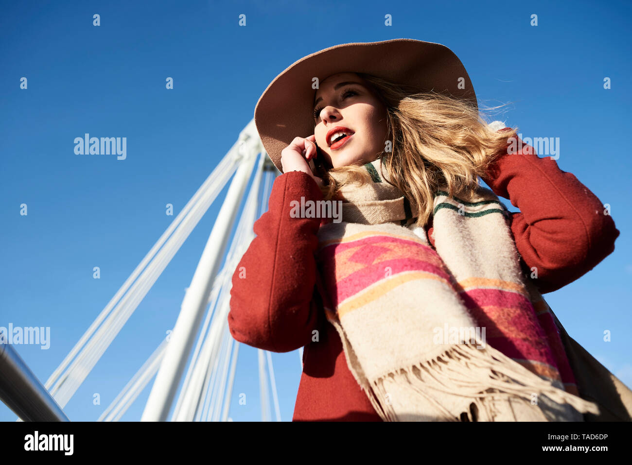 UK, London, stilvolle junge Frau mit Handy über die Millennium Bridge Stockfoto