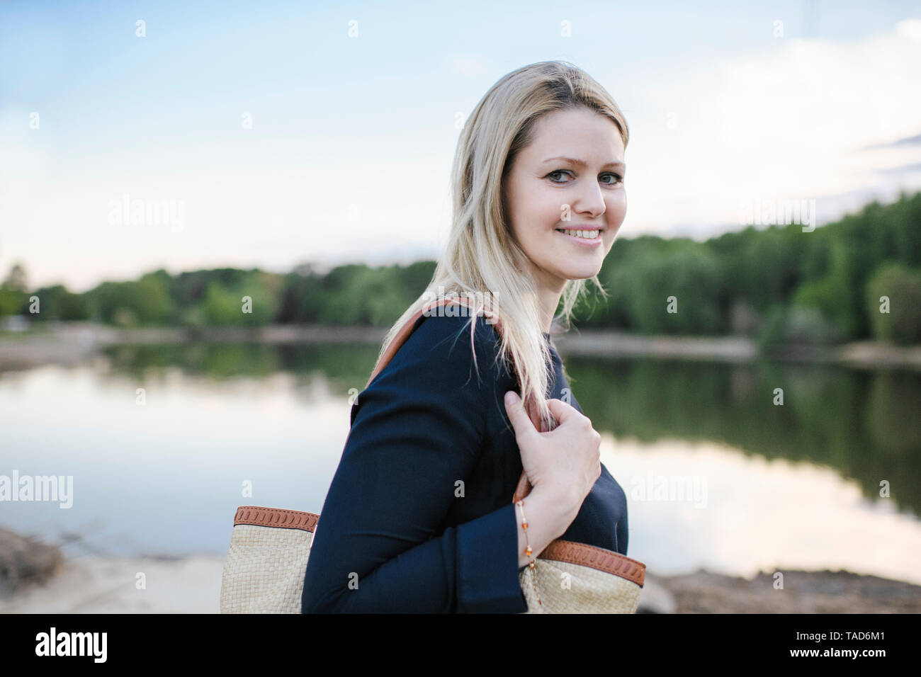 Portrait von lächelnden blonde Frau an einem See Stockfoto
