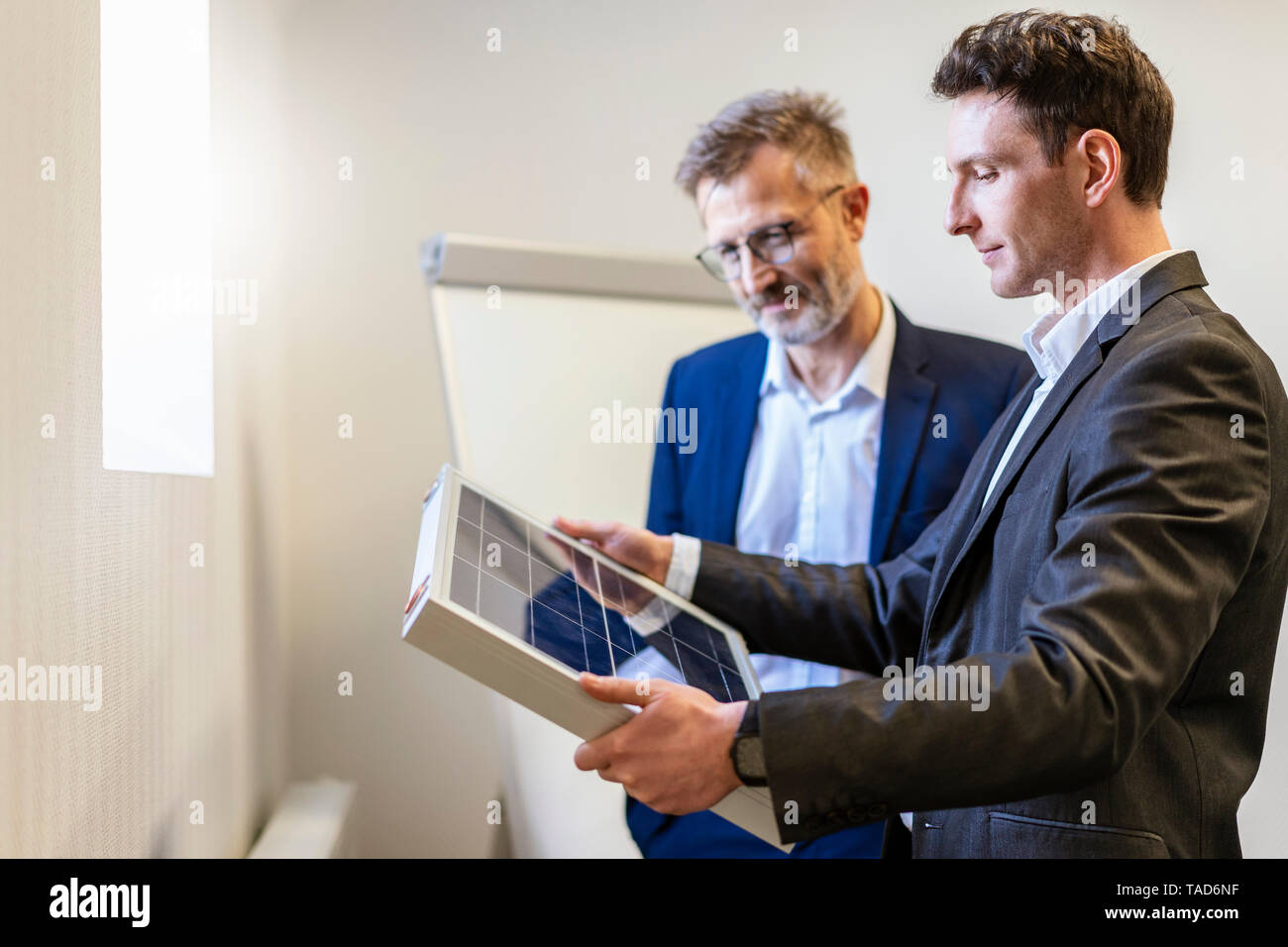 Zwei Geschäftsleute in Office mit Solarzelle diskutieren Stockfoto