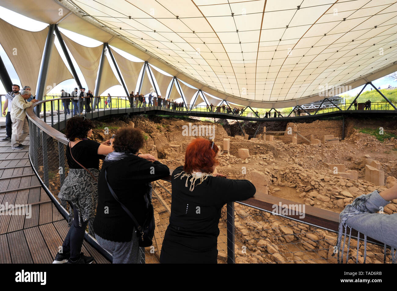 Besucher mit Blick auf die Ausgrabungen der antiken Stein ceremonial site an Gobekli Tepe in Sanliurfa, Türkei Stockfoto