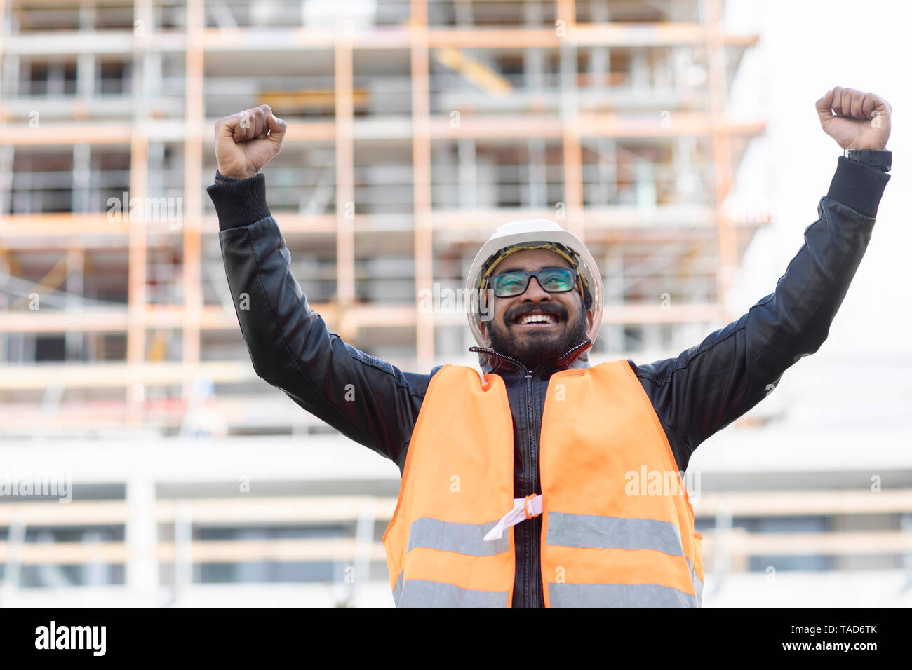 Portrait von glücklichen Konstrukteur vor der Baustelle das Tragen von Helm und Warnweste Stockfoto