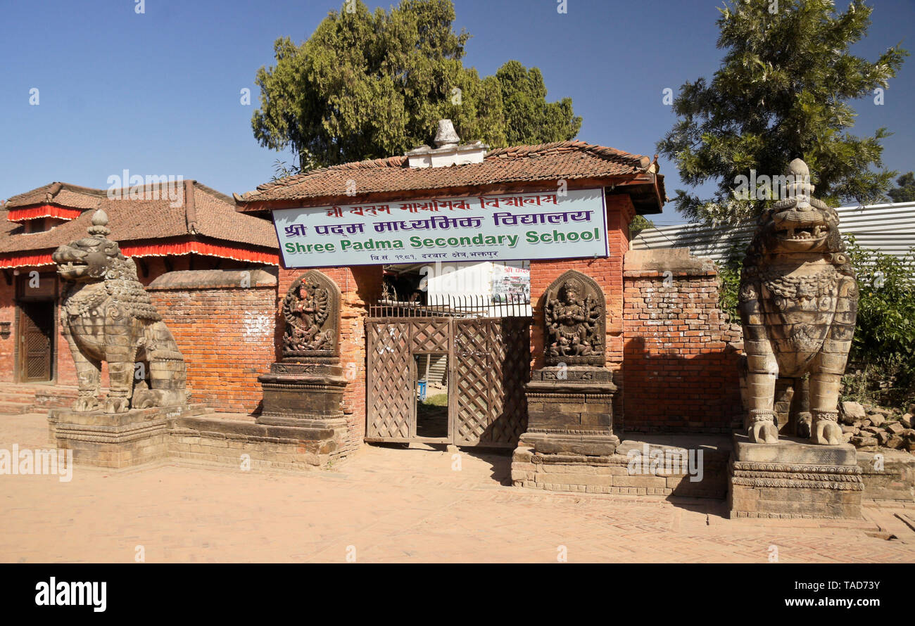 Löwen aus Stein und Schnitzereien von bhairab (Shiva) und Ugrachandi (Durga) flankieren den Eingang zu einer weiterführenden Schule in der Nähe des Durbar Square, Kathmandu, Bhaktapur V Stockfoto