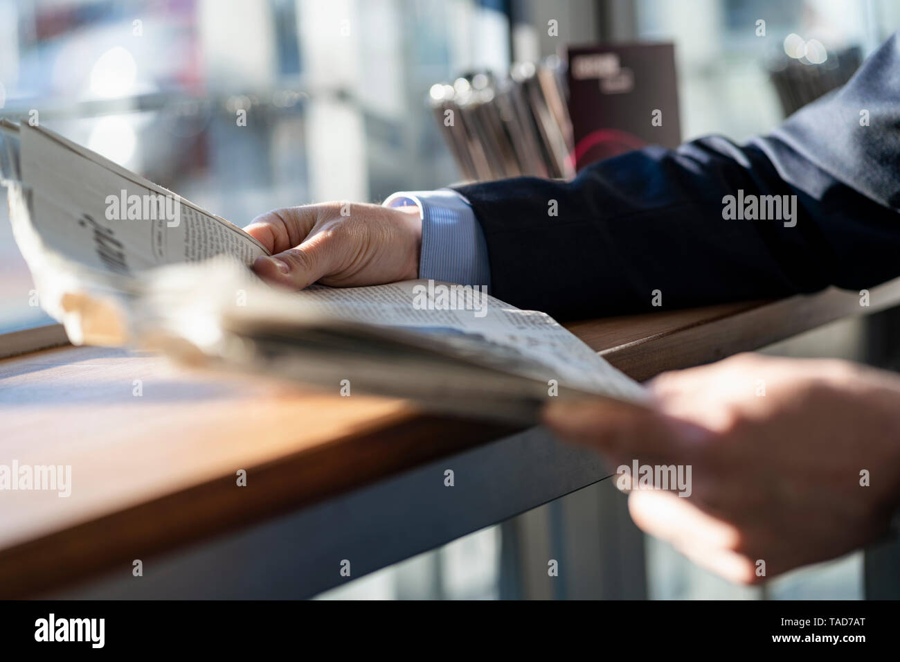 Close-up des Geschäftsmannes lesen Zeitung, die sich am Fenster in einem Cafe Stockfoto