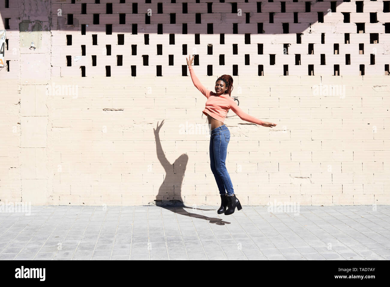 Glückliche junge Frau in die Luft springen Stockfoto