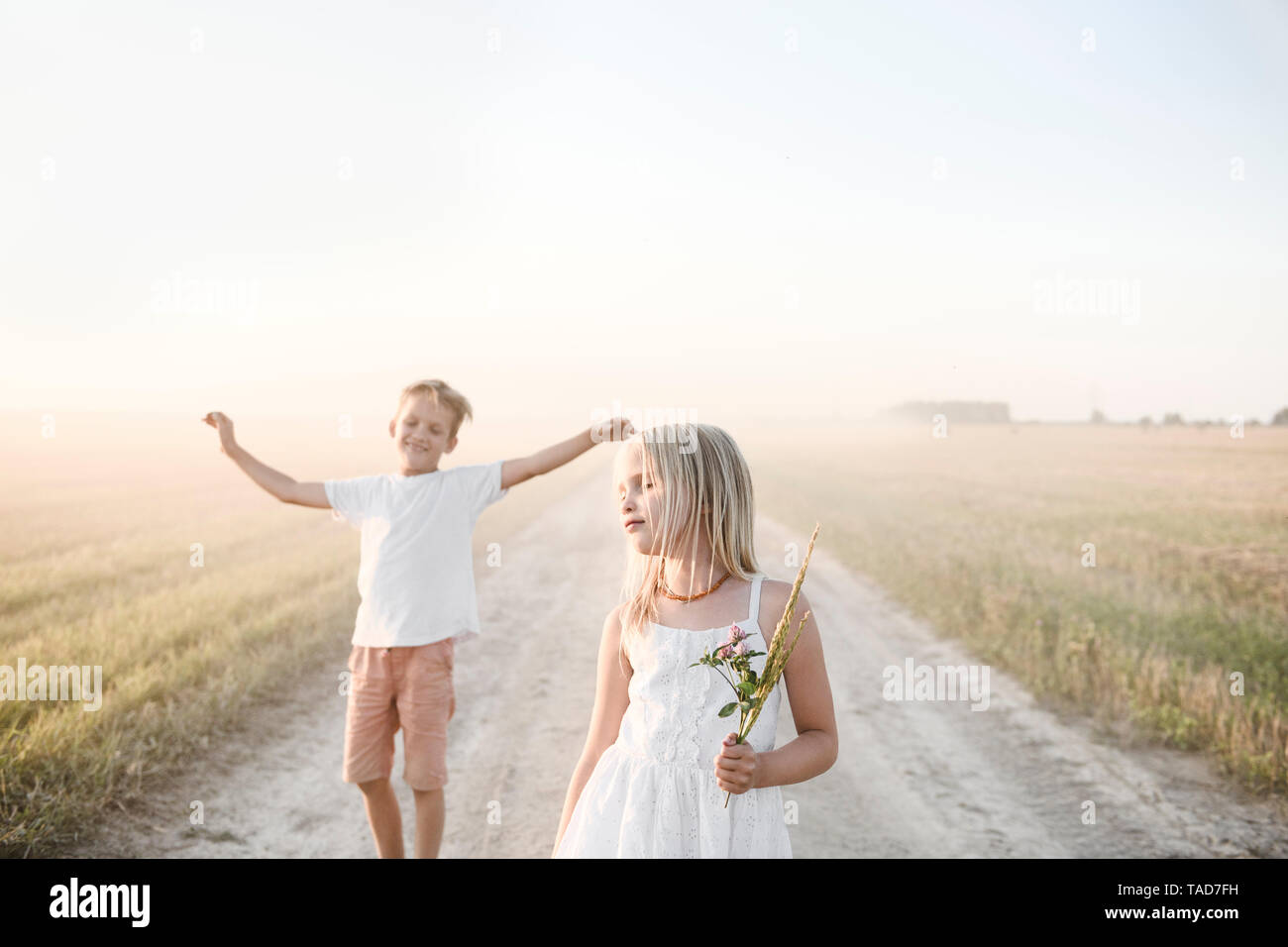 Mädchen und Jungen auf einer ländlichen Feldweg Stockfoto