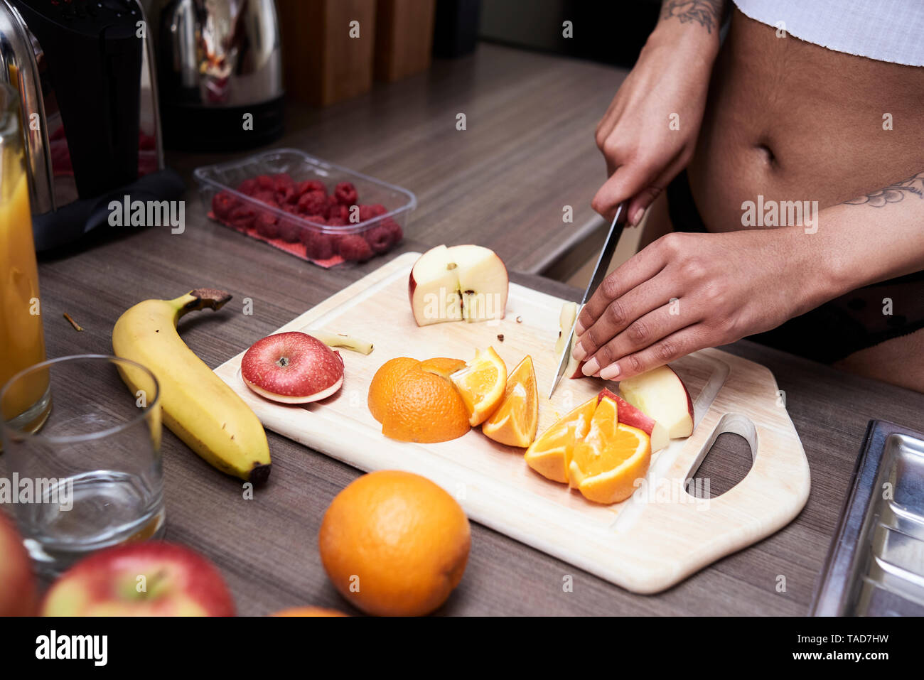 Nahaufnahme der jungen Frau schneiden Obst in der Küche Stockfoto
