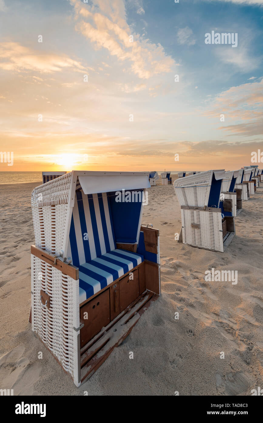 Deutschland, Sylt, Nordsee, Sandstrand mit Kapuze liegen im Sonnenuntergang Stockfoto
