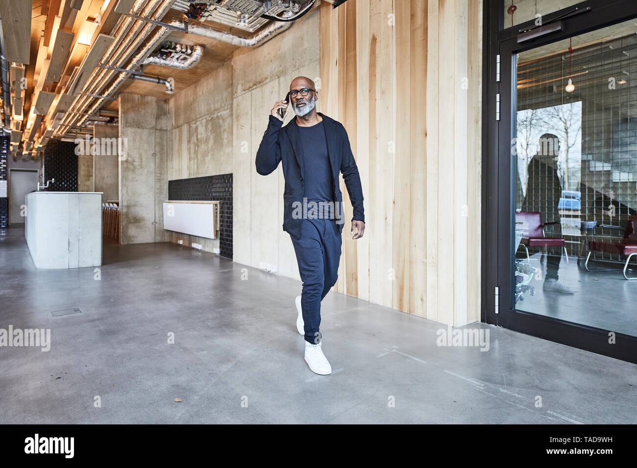 Reifen Geschäftsmann auf Handy wandern in modernen Büro Stockfoto