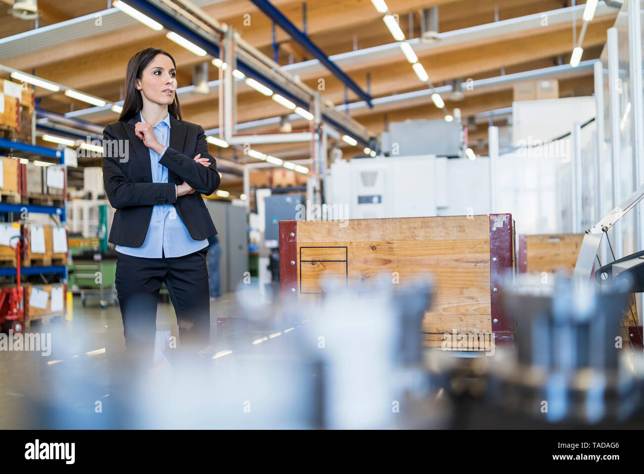 Geschäftsfrau stehend in einer Fabrik auf der Suche Stockfoto