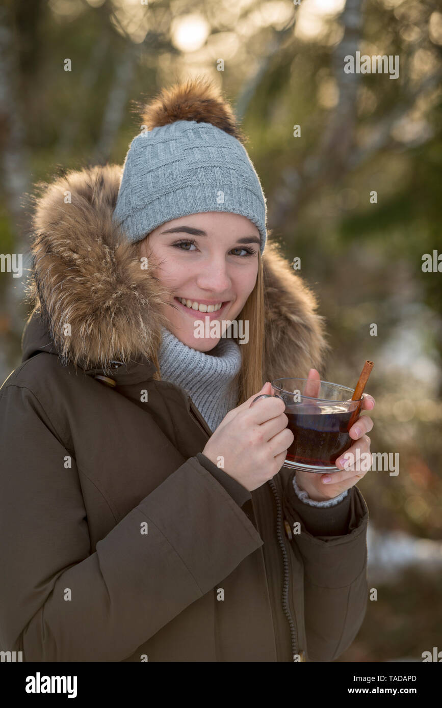 Porträt der lächelnde Junge Frau trinkt Tee im Winter Stockfoto