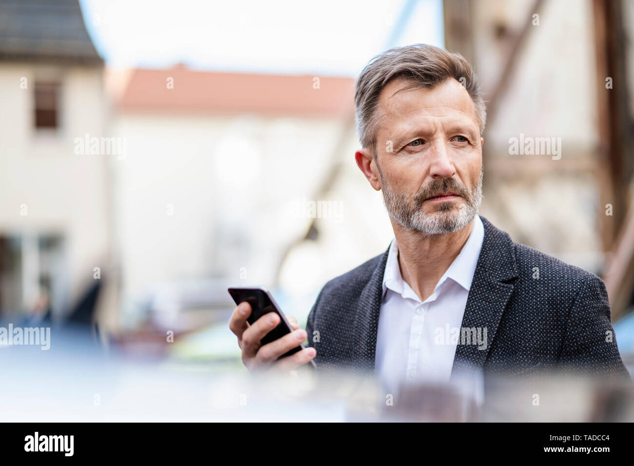 Portrait von Reifen Geschäftsmann mit Mobiltelefon gerade etwas Stockfoto