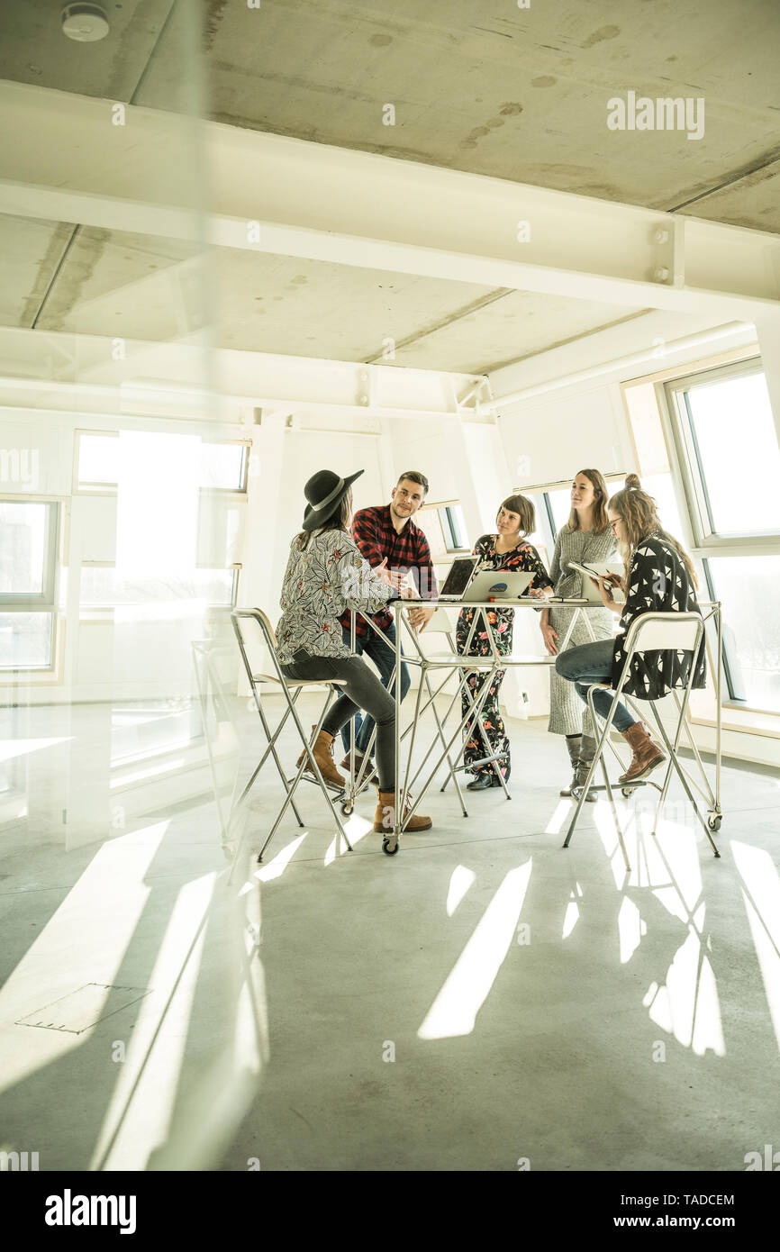 Gruppe der kreativen Profis in eine Besprechung in einem hellen Büro, diskutieren neue Lösungen Stockfoto