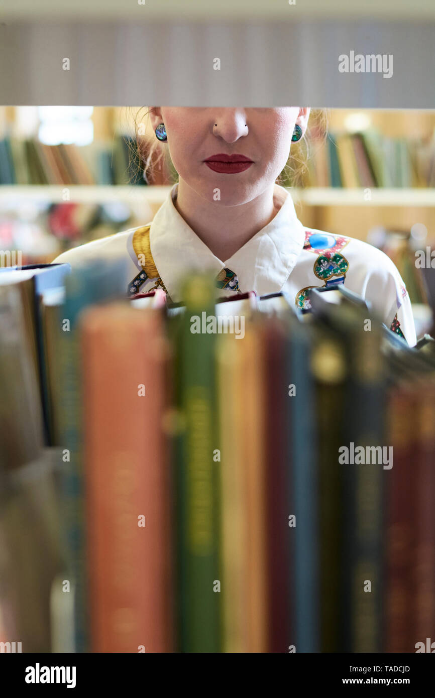 Studentin in einer öffentlichen Bibliothek, rote Lippen Stockfoto