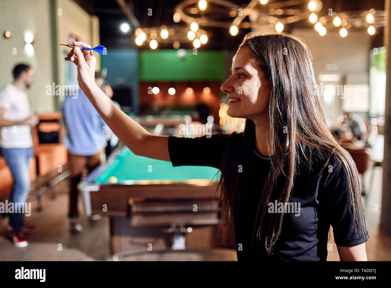 Lächelnden jungen Frau spielen Dart Stockfoto