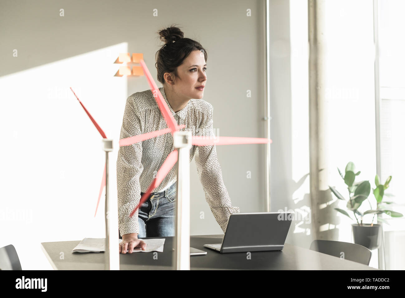 Geschäftsfrau mit wind turbine Modelle und Laptop auf dem Schreibtisch im Büro Stockfoto