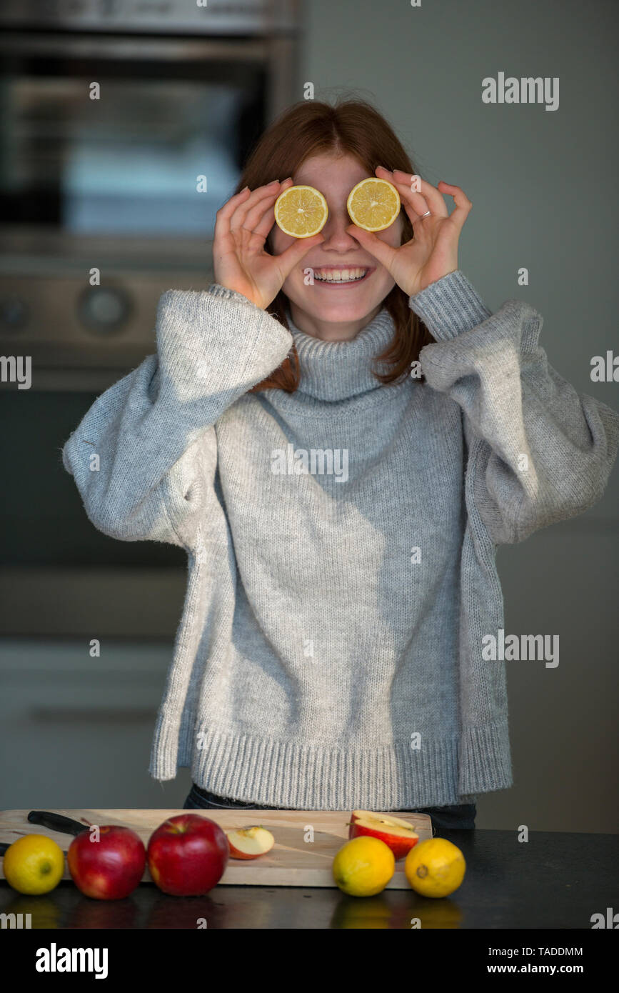 Lachend Jugendmädchen holding Zitrone Hälften der vor ihren Augen Stockfoto