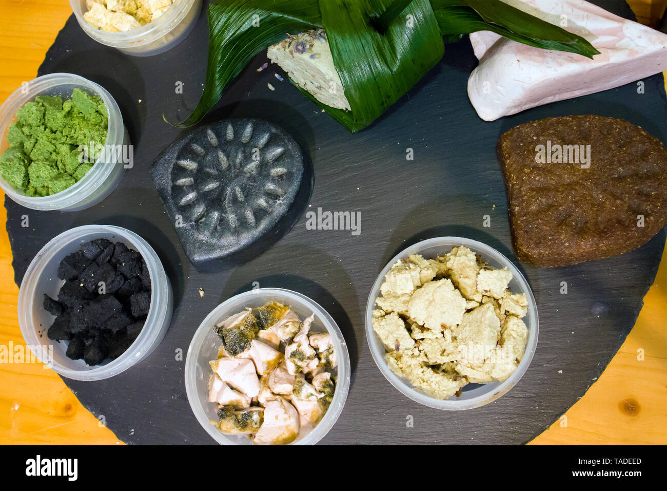 Kunststoffkästen mit Stücken von Naturkosmetik und handgemachte Seife auf einem Holzbrett angeordnet Stockfoto