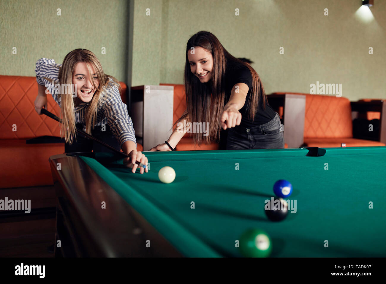 Zwei glückliche Freunde zusammen spielen Billard Stockfoto