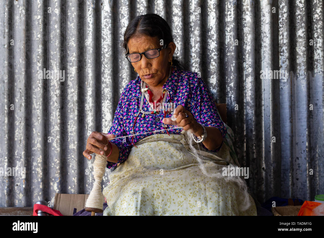 Tibeter im Exil lebenden Frau in Flüchtlingslager in Nepal, ein Leben von Weben an einem Webstuhl. Stockfoto