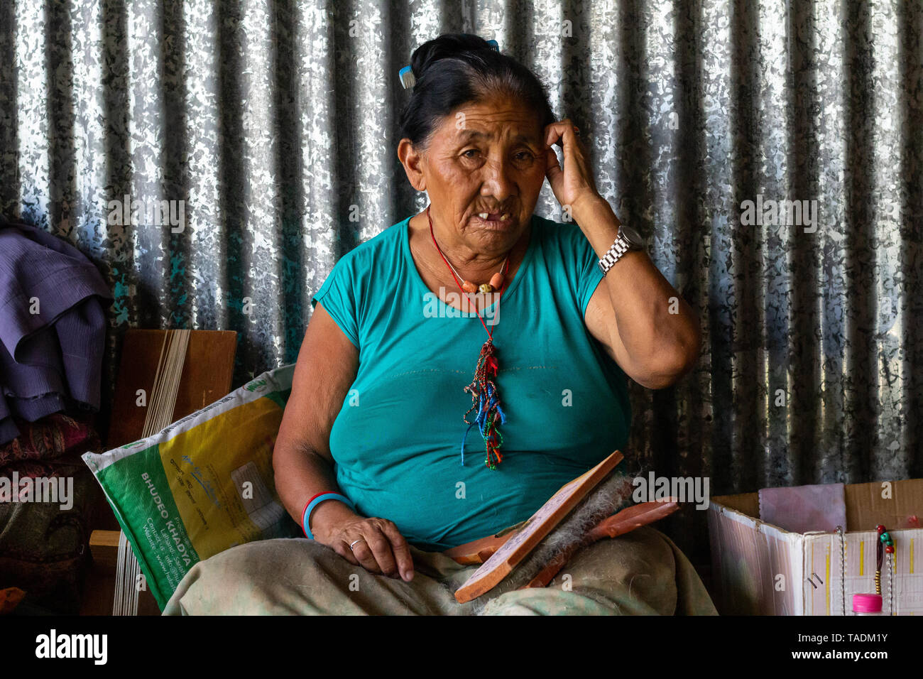 Tibeter im Exil lebenden Frau in Flüchtlingslager in Nepal, ein Leben von Weben an einem Webstuhl. Stockfoto