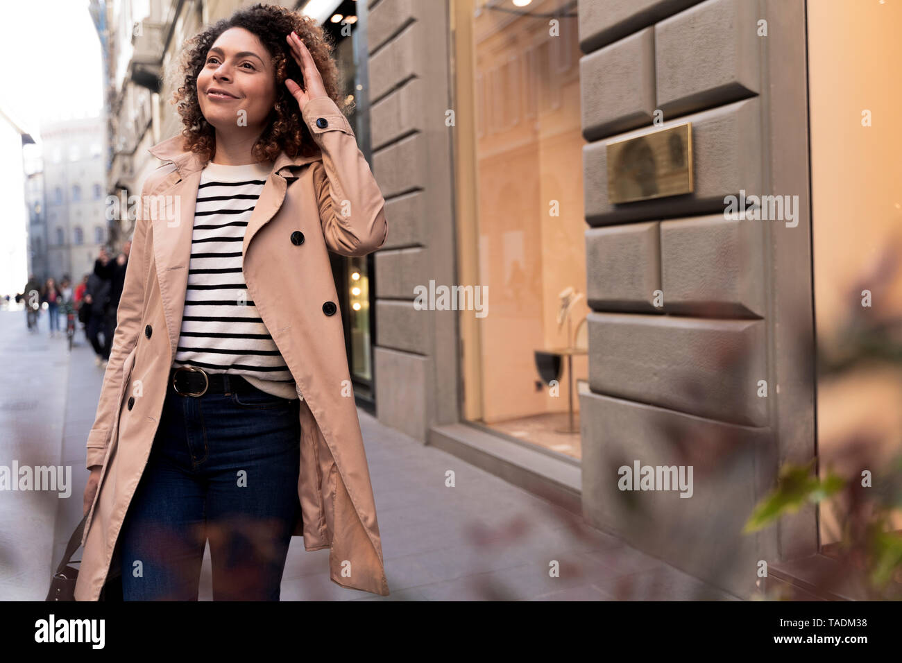 Lächelnde Frau zu Fuß in der Stadt Stockfoto