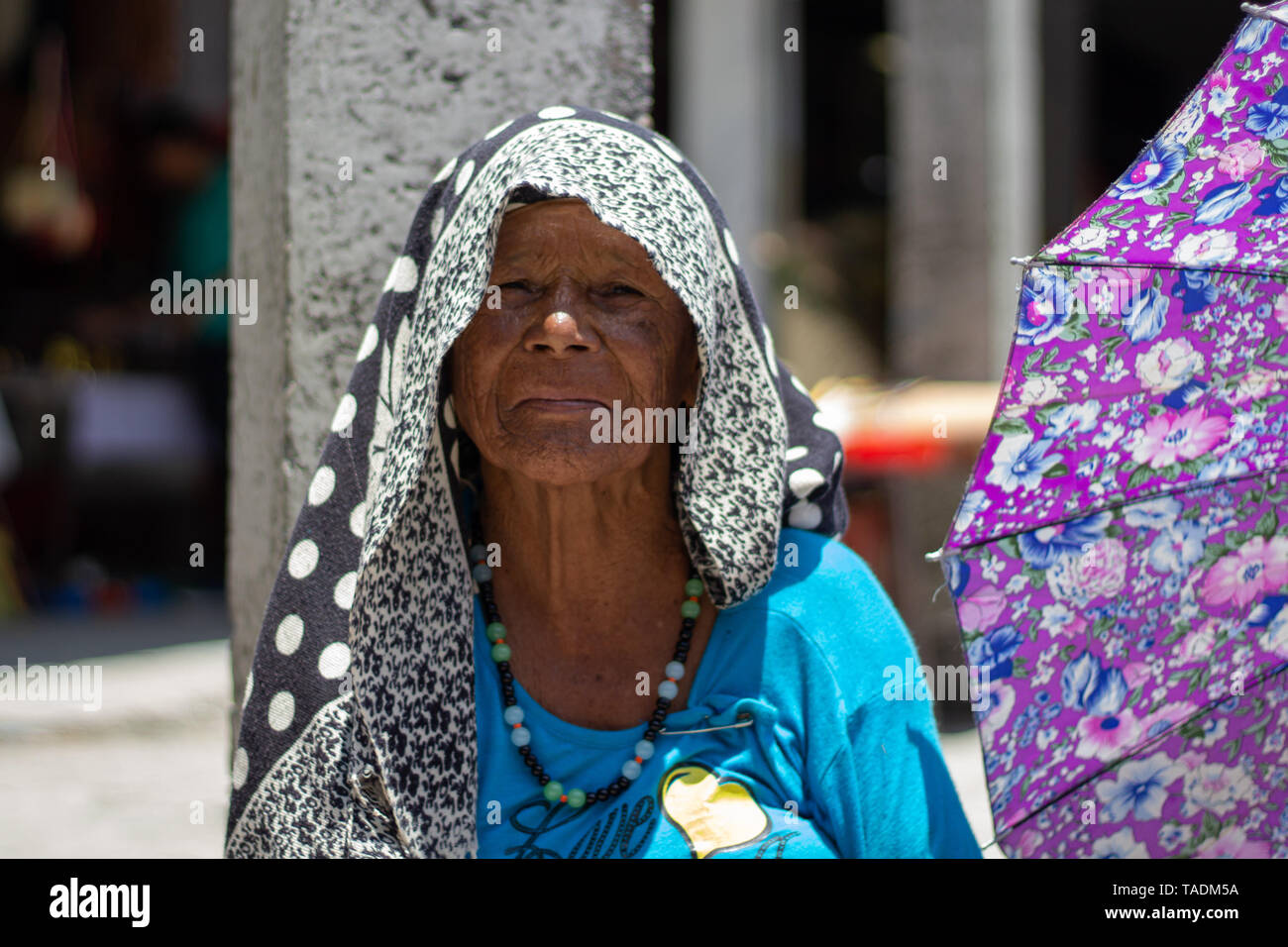 Indische Dame mit schwarzem Tuch auf dem Kopf und lila Schirm  Stockfotografie - Alamy