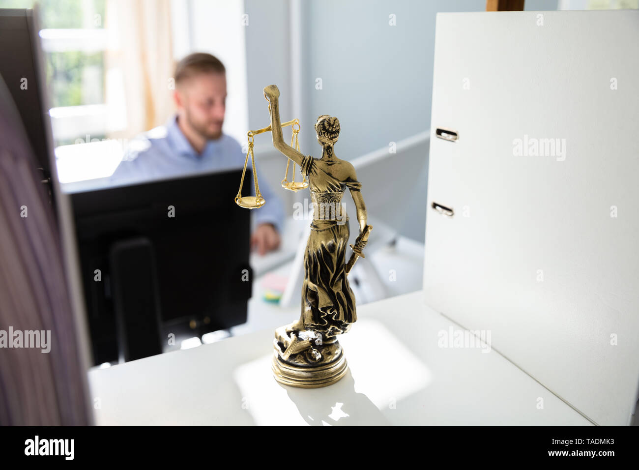 Gerechtigkeit Statue auf Regal und Anwalt Arbeiten im Büro im Hintergrund Stockfoto