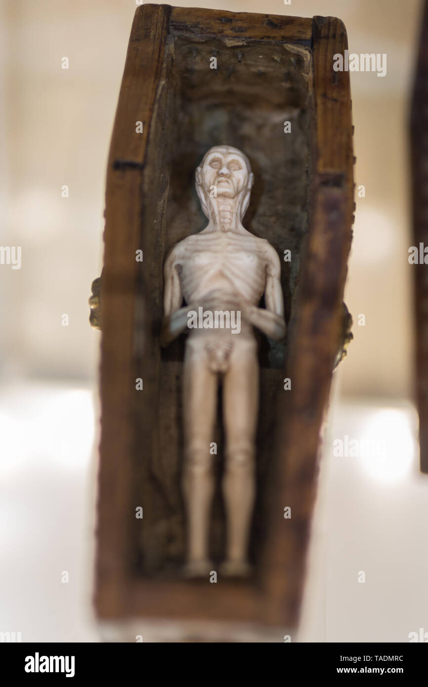 Kleine Statuette zeigt eine Leiche in einem hölzernen Sarg. Stockfoto