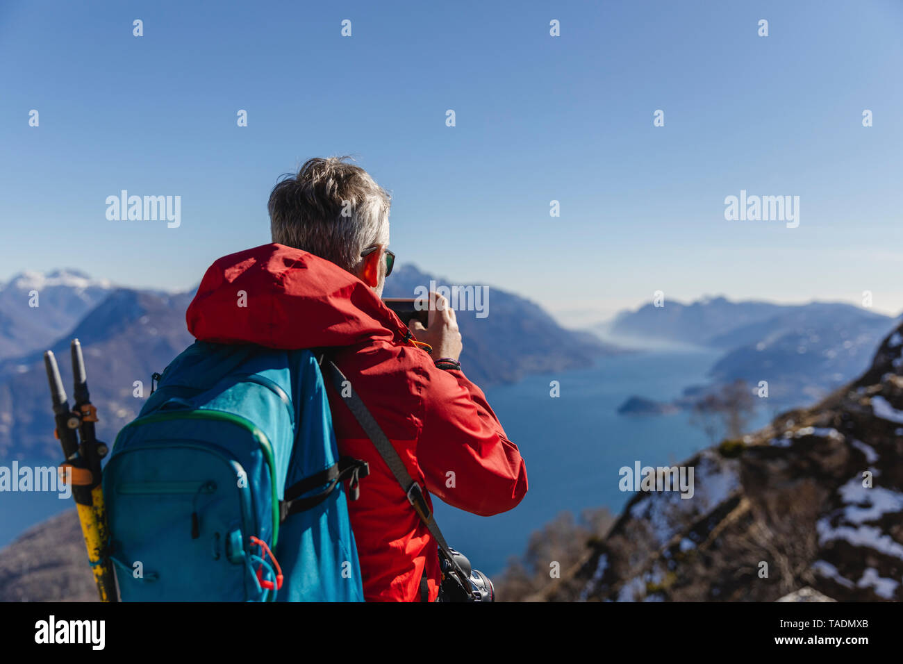 Italien, Como, Mann auf einer Wanderung in den Bergen über dem Comer See, Foto mit Handy Stockfoto