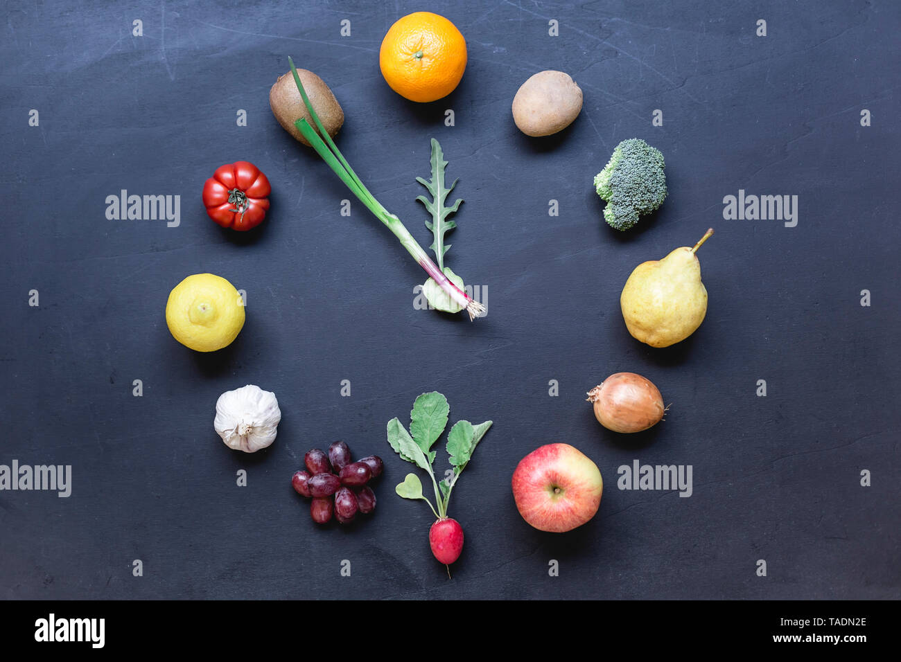 Obst und Gemüse buliding Uhr auf dunklem Boden Stockfoto