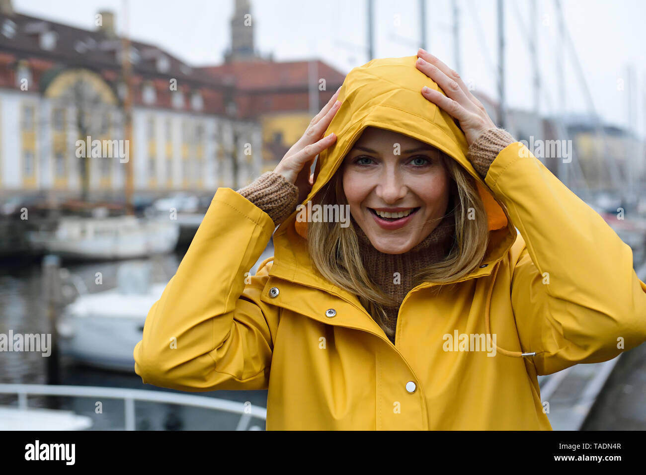 Dänemark, Kopenhagen, Porträt von Frau am Hafen der Stadt im regnerischen Wetter Stockfoto