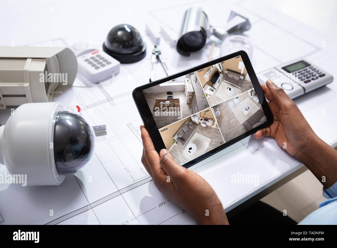 Einen erhöhten Blick auf die Person, die die Aufnahmen auf Digital Tablet mit Ausrüstungsgegenstände für die Gefahrenabwehr auf dem Bauplan Stockfoto
