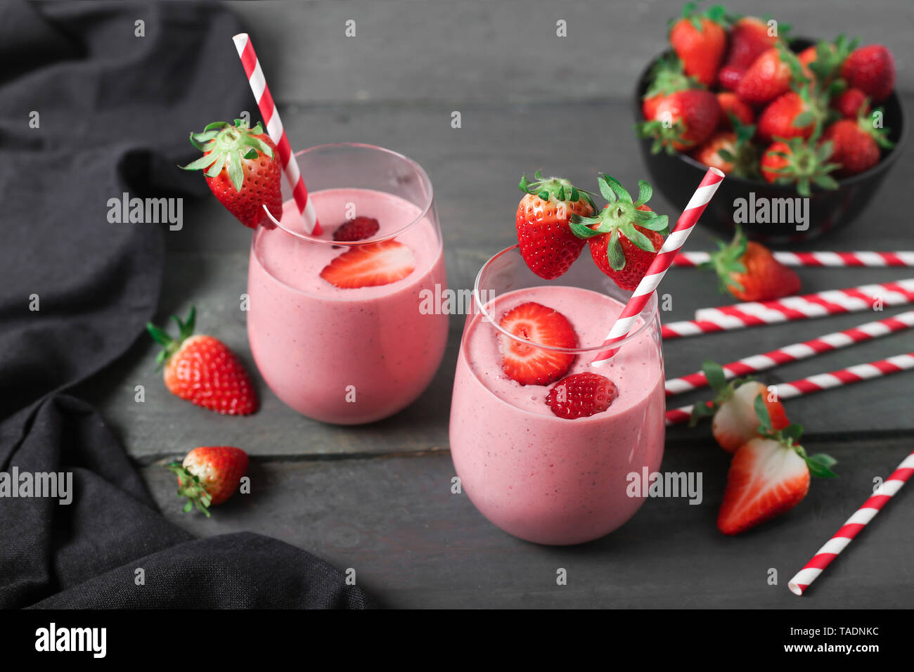 Gläser Erdbeer Smoothie und Erdbeeren auf dunklem Holz Stockfoto