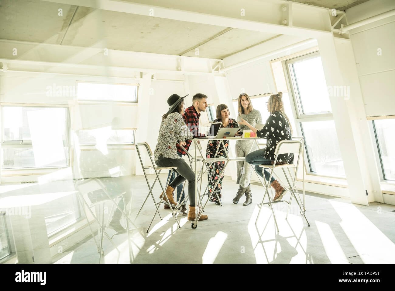 Gruppe der kreativen Profis in eine Besprechung in einem hellen Büro, diskutieren neue Lösungen Stockfoto