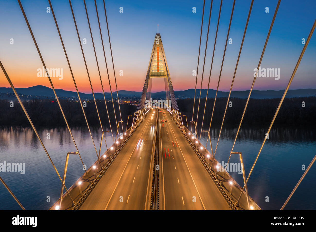 Budapest, Ungarn - Luftaufnahme des schönen Schrägseilbrücke Megyeri Brücke über die Donau mit Blau und Orange Sky nach Sonnenuntergang Stockfoto