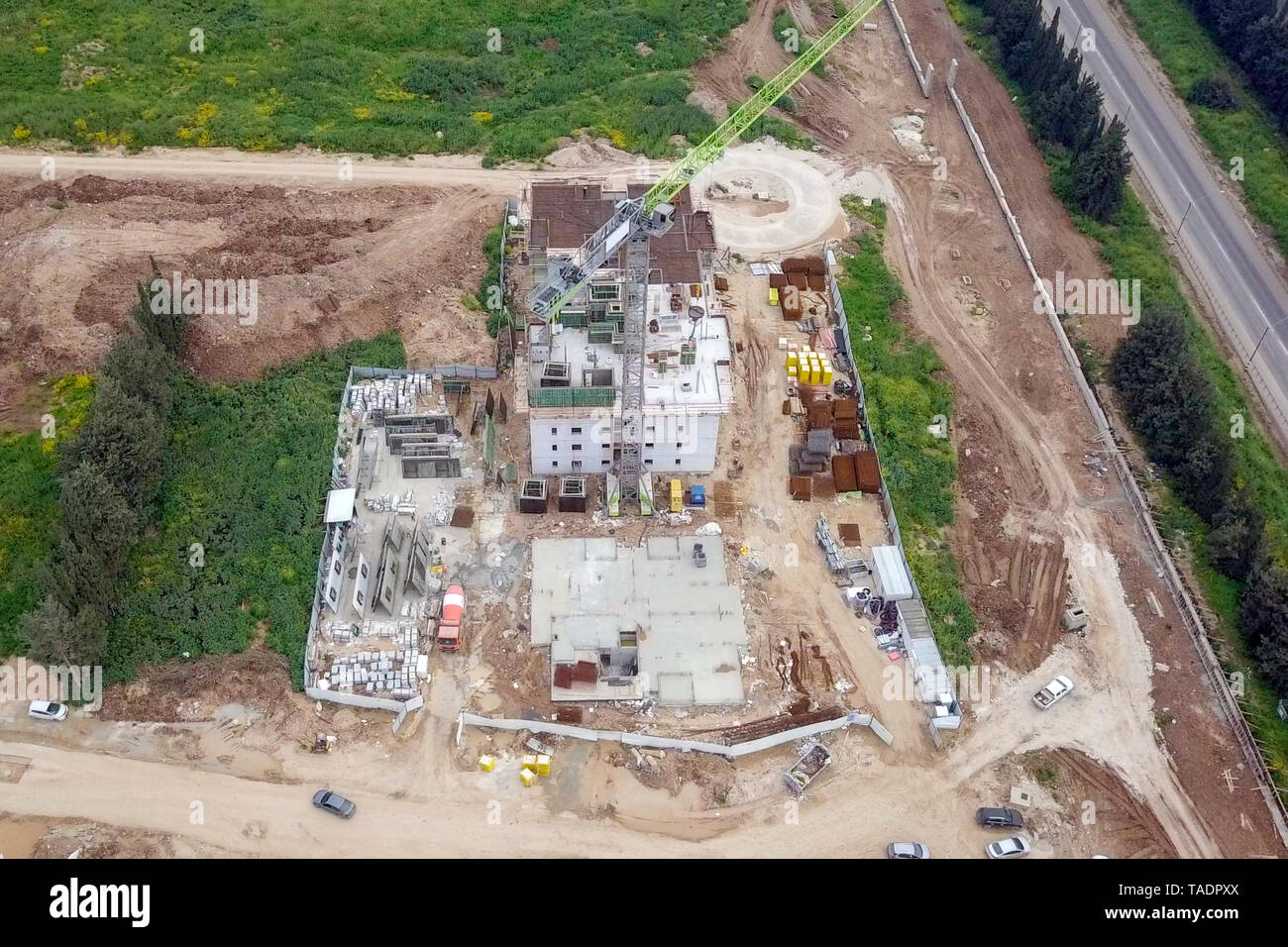 Baustelle - Luftbild eines großen Wohn- verbindung während der frühen Phasen der Konstruktion, mit Kränen und grünen Umgebung. Stockfoto