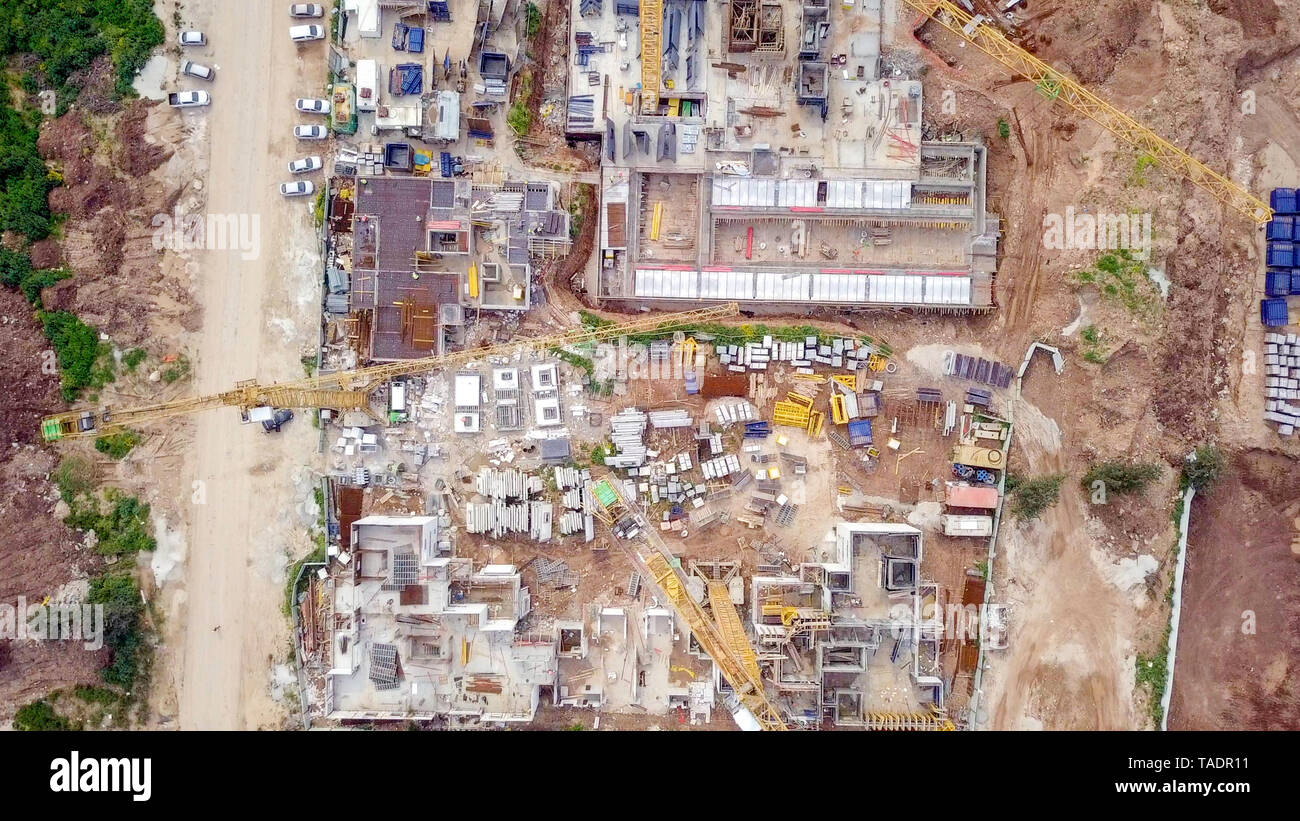 Baustelle - Luftbild eines großen Wohn- verbindung während der frühen Phasen der Konstruktion, mit Kränen und grünen Umgebung. Stockfoto